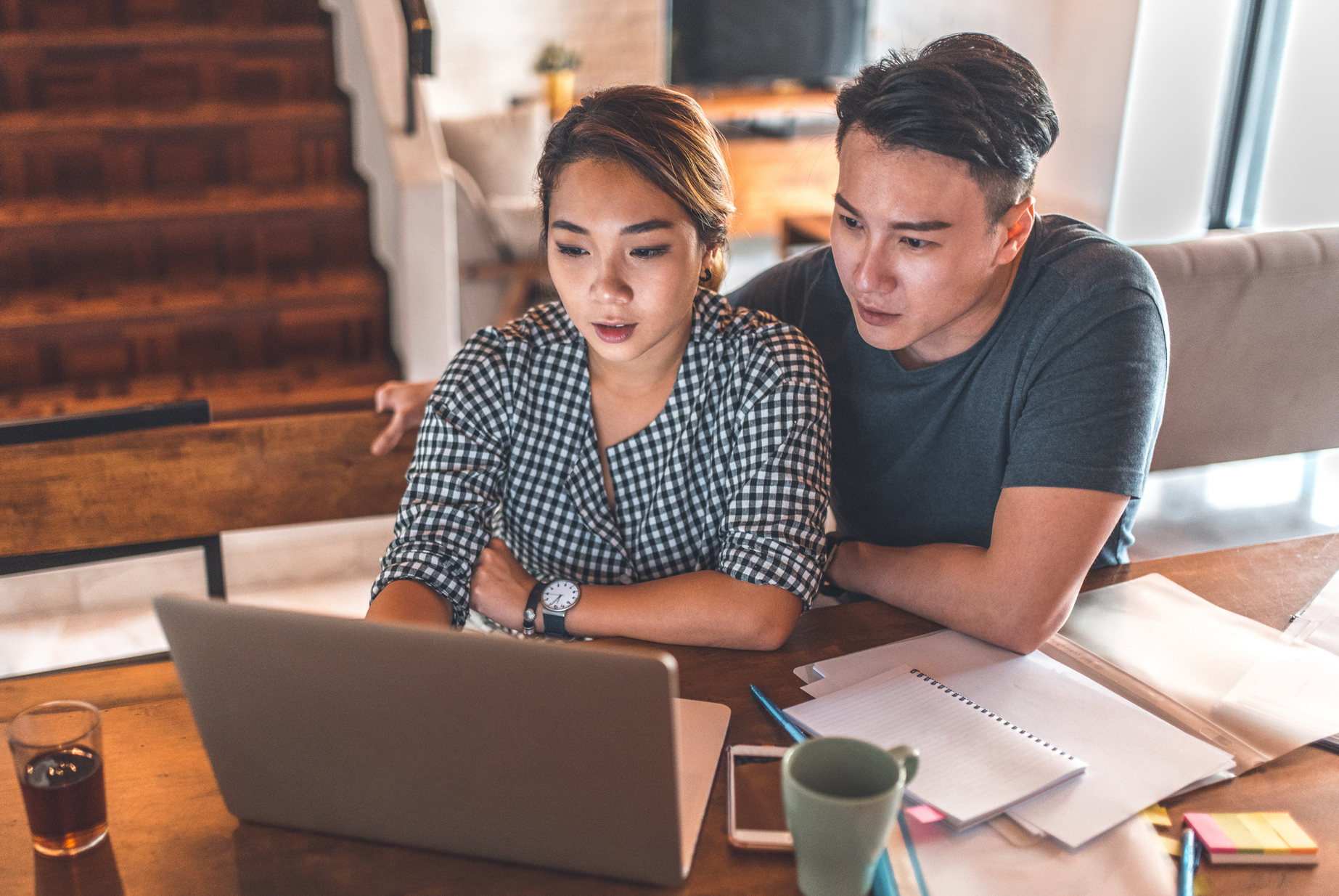 Serious couple using laptop while sitting at home