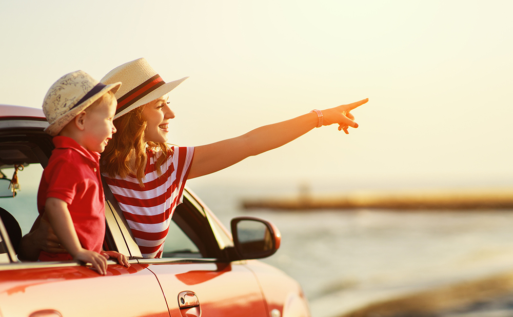 happy family mother and child boy goes to summer travel trip in car