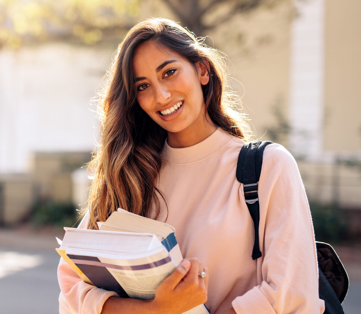 Female college student with books outdoors