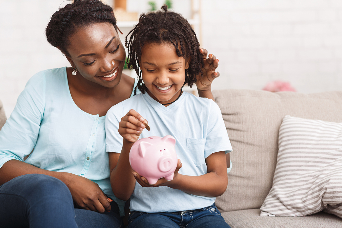 African american family inserting money to piggybank